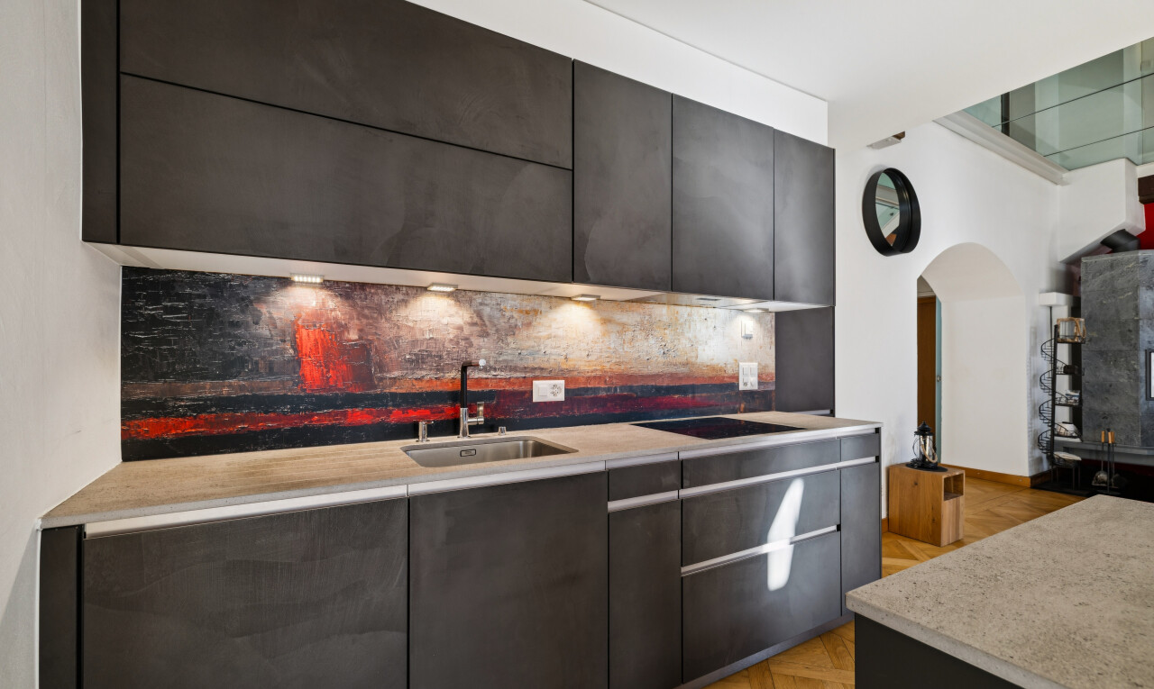 cuisine avec light countertops, passages en arc, armoires à panneau plat, flat panel cabinets, et évier
