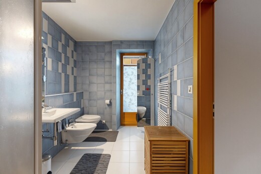 full bathroom featuring tile walls, a towel warmer, radiator heating unit, a bidet, and vanity