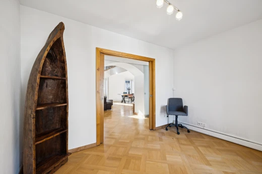 couloir avec éclairage sur rail, drywall, cloison sèche, passages en arc, et light floor