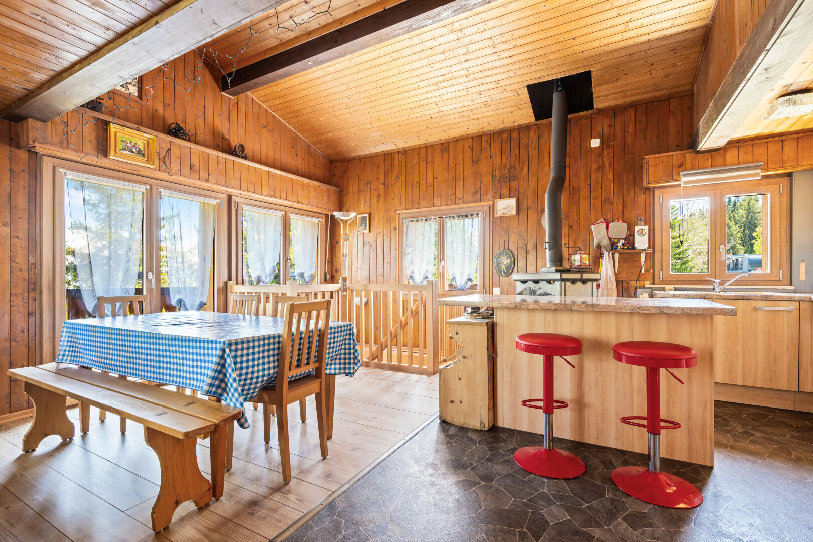 salle à manger avec mur en bois, wood wall, plafond voûté, vaulted ceiling, et lumière naturelle