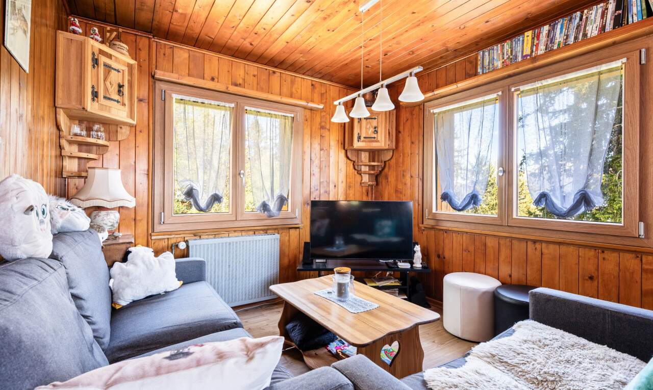 living area featuring wood ceiling, wooden walls, wood finished floors, and radiator heating unit
