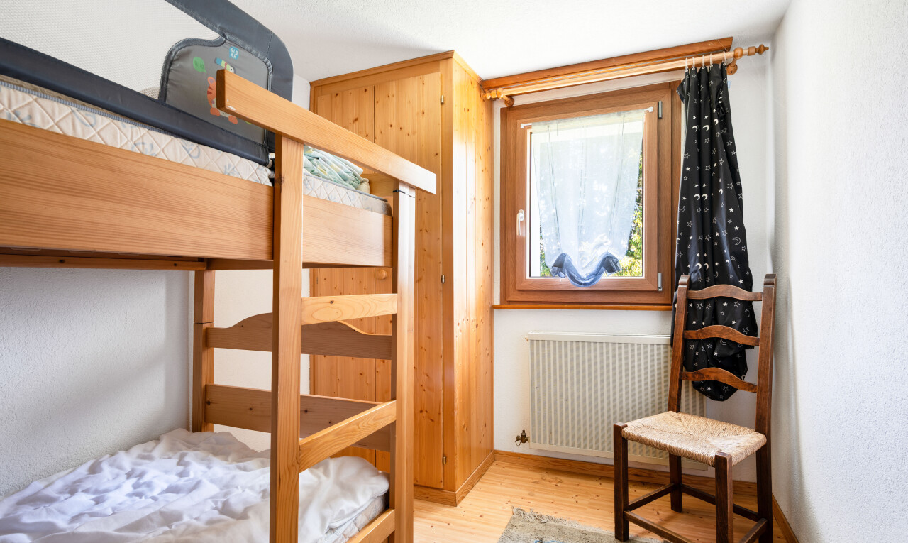 chambre avec radiateur, sol en finition bois, wood finish floor, inside property, et lumière naturelle