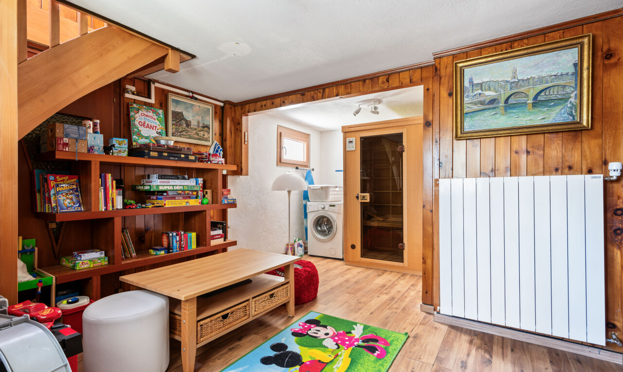 living room featuring light wood-type flooring, washer / clothes dryer, wooden walls, and radiator