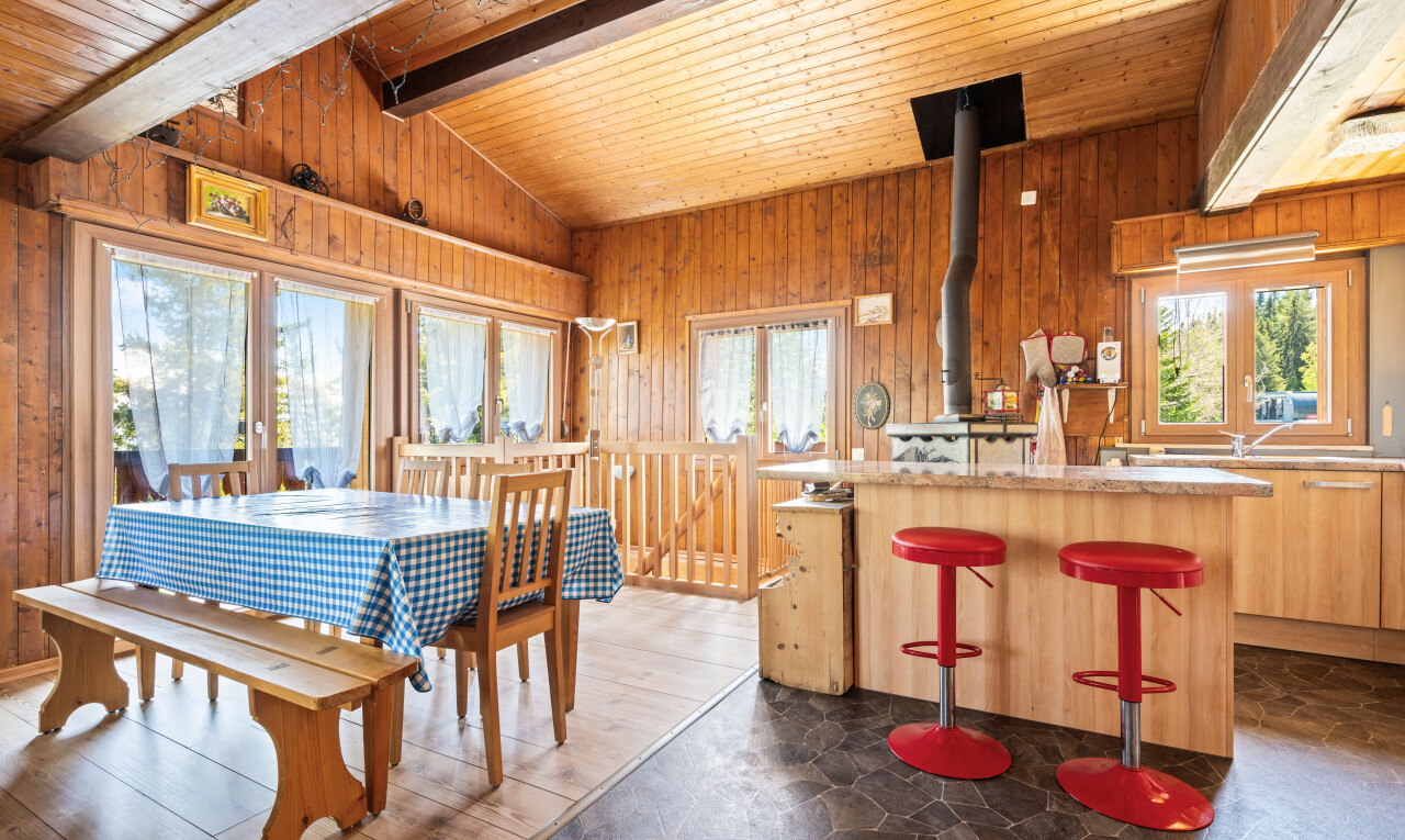 salle à manger avec mur en bois, wood wall, plafond voûté, vaulted ceiling, et lumière naturelle