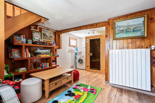 salon avec wood finish floor, sol en finition bois, inside property, lave-linge et sèche-linge, et wood wall