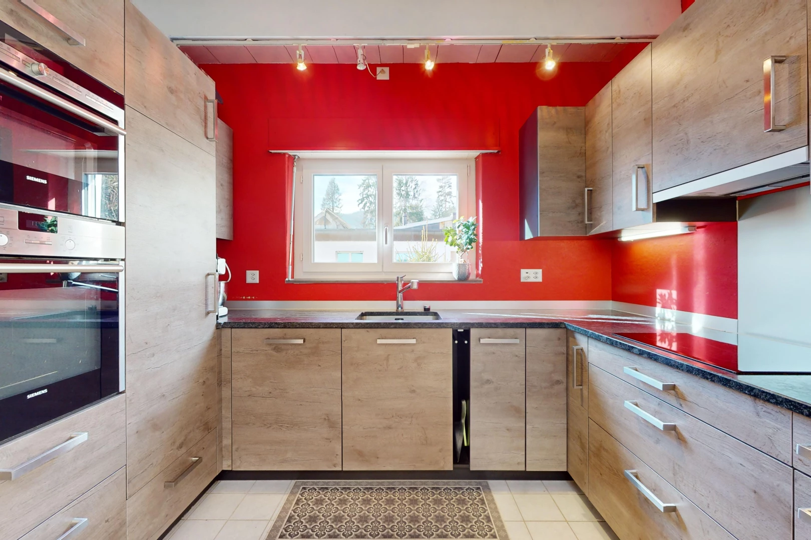 cuisine avec carrelage, lumière naturelle, vasque, éclairage sur rail, et four double