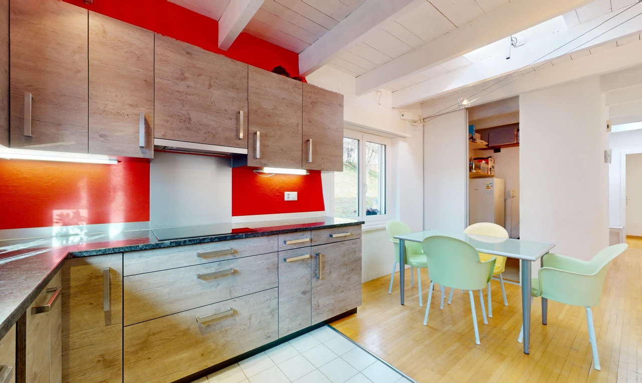 cuisine avec plancher de bois, carrelage, lumière naturelle, poutres apparentes, et plan de travail