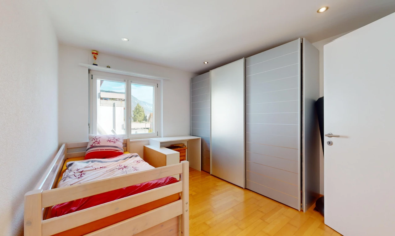 chambre avec placard, plancher de bois, et lumière naturelle
