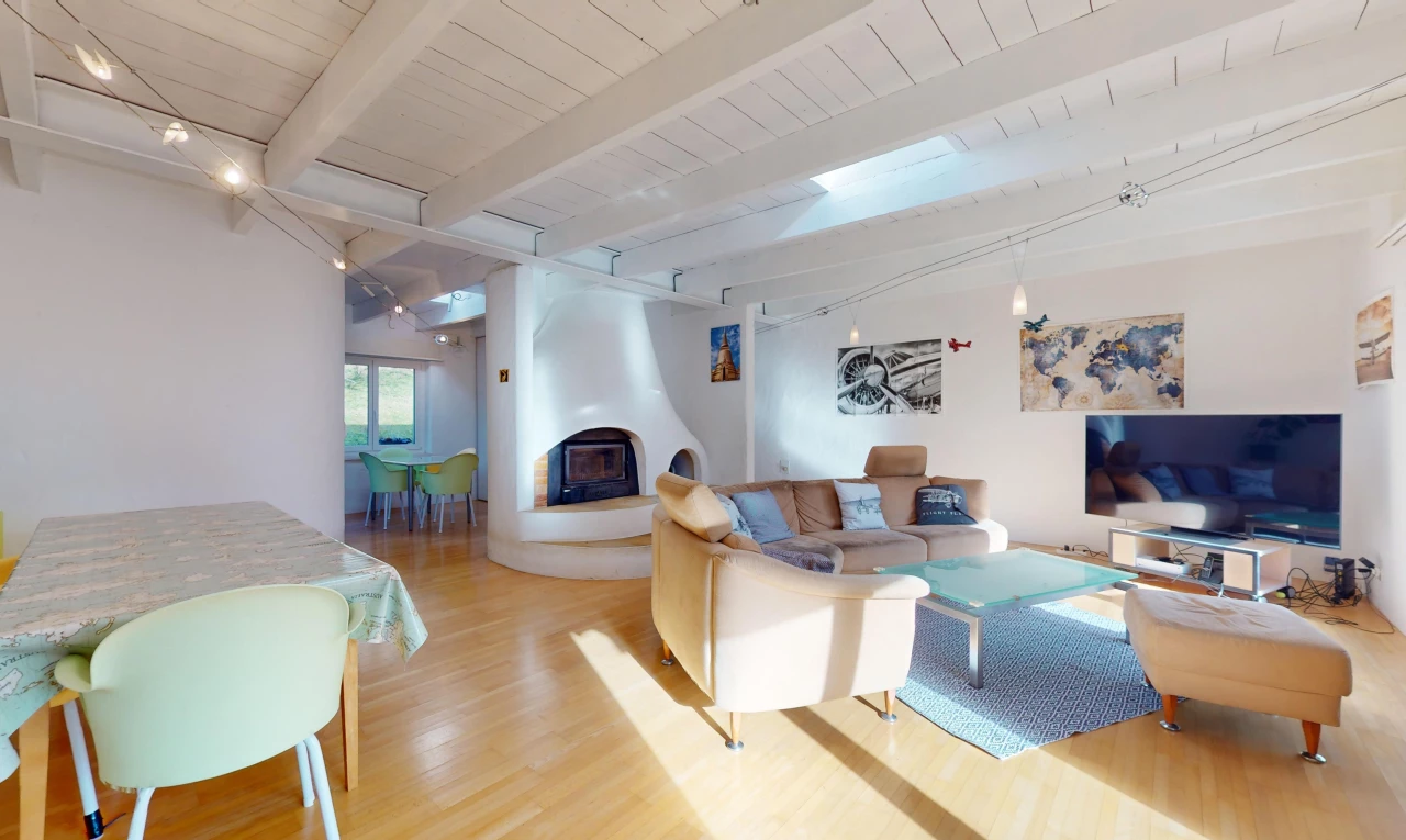 salon / salle à manger avec poutres apparentes, plancher de bois, lumière naturelle, télévision, et cheminée