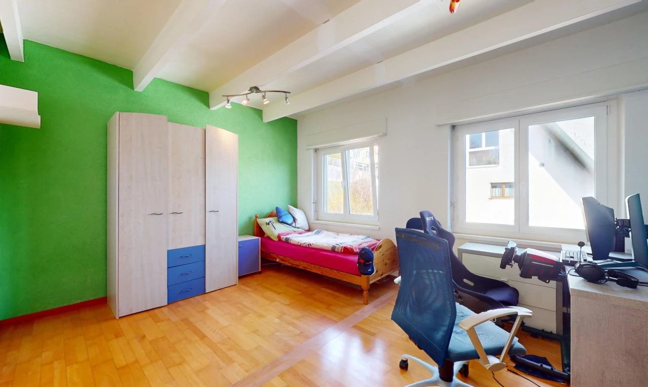 chambre avec poutres apparentes, télévision, plancher de bois, et lumière naturelle