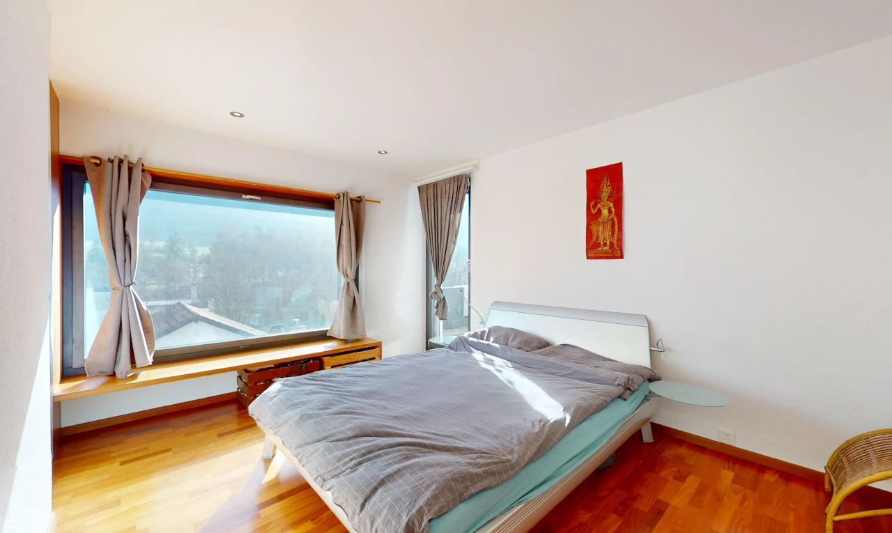 chambre avec lumière naturelle et plancher de bois