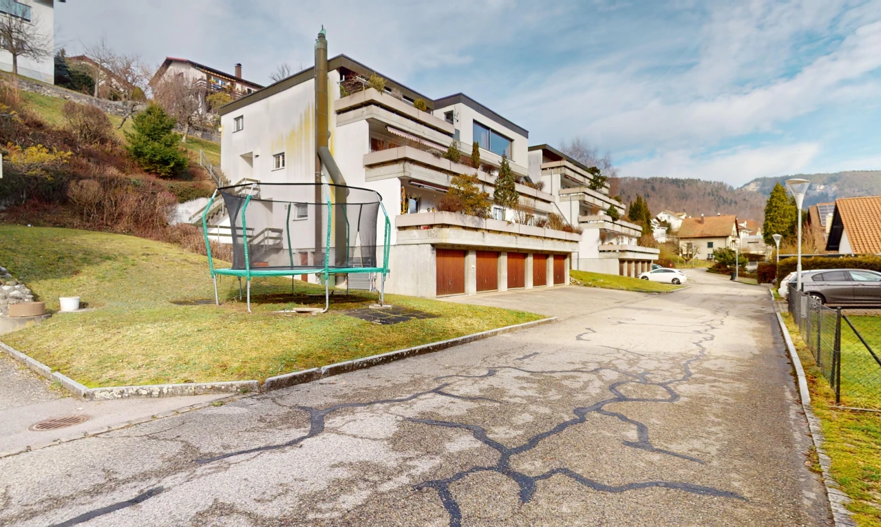 façade avec garage intégré, vue résidentielle, pelouse, et trampoline