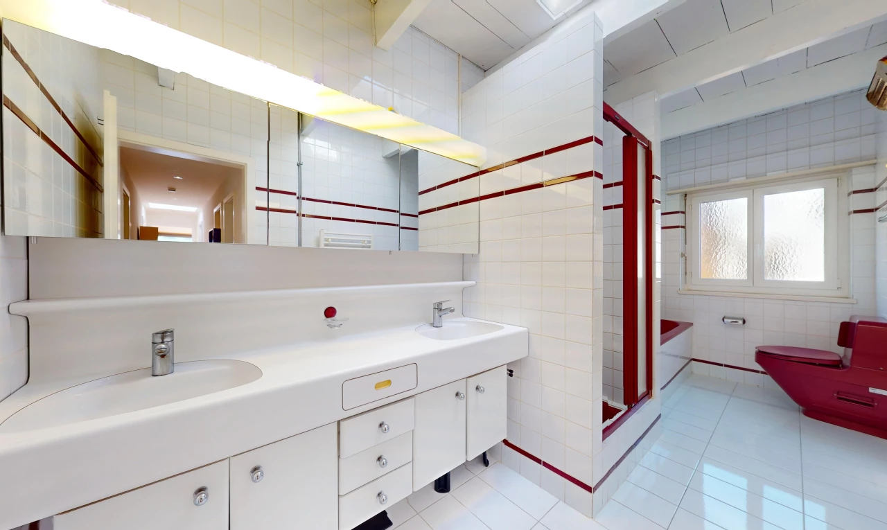 salle de bain avec double vasque, mur carrelé, meuble-lavabo, carrelage, et lumière naturelle