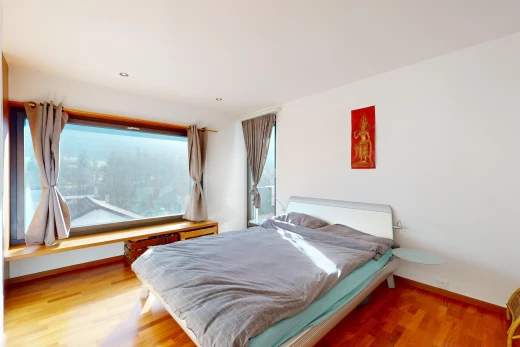 chambre avec lumière naturelle et plancher de bois