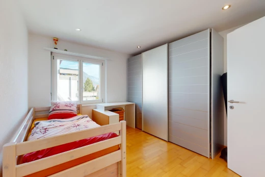 chambre avec placard, plancher de bois, et lumière naturelle