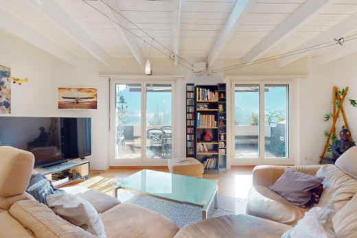 wohnzimmer mit natürliches licht, fernsehen, und balkendecke