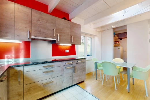 cuisine avec plancher de bois, carrelage, lumière naturelle, poutres apparentes, et plan de travail
