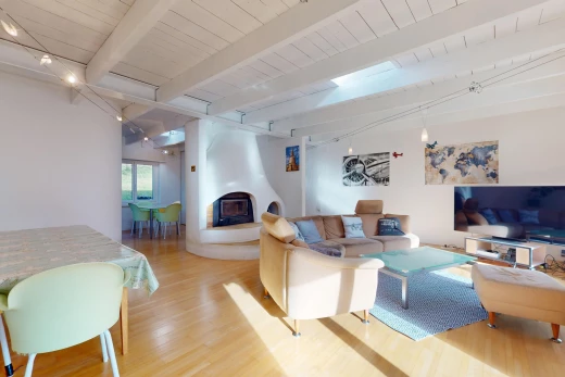 salon / salle à manger avec poutres apparentes, plancher de bois, lumière naturelle, télévision, et cheminée