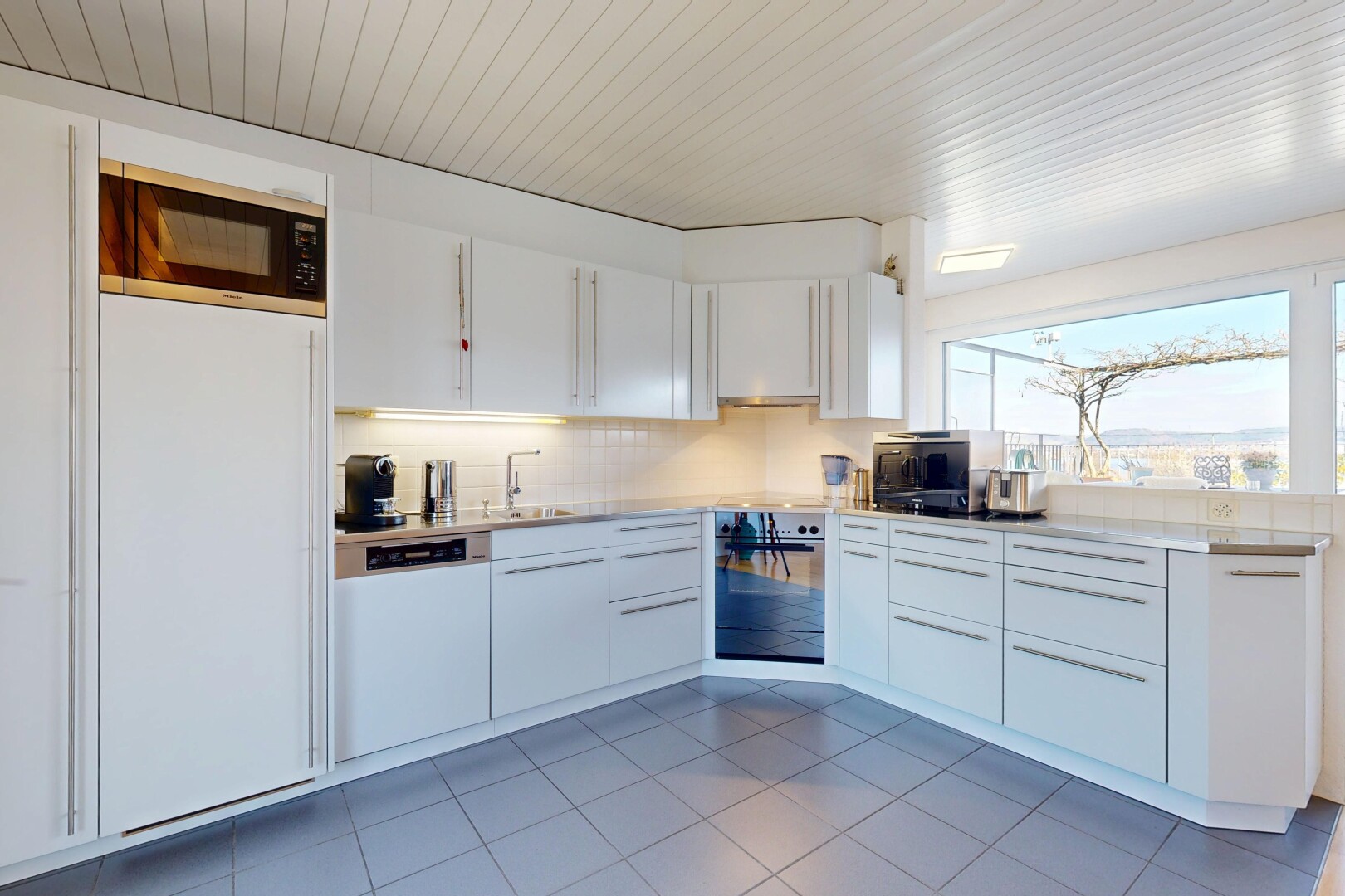 küche mit arbeitsplatten, weiße schränke, mikrowelle, küchenrückwand beim Herd, und küchenrückwand beim herd