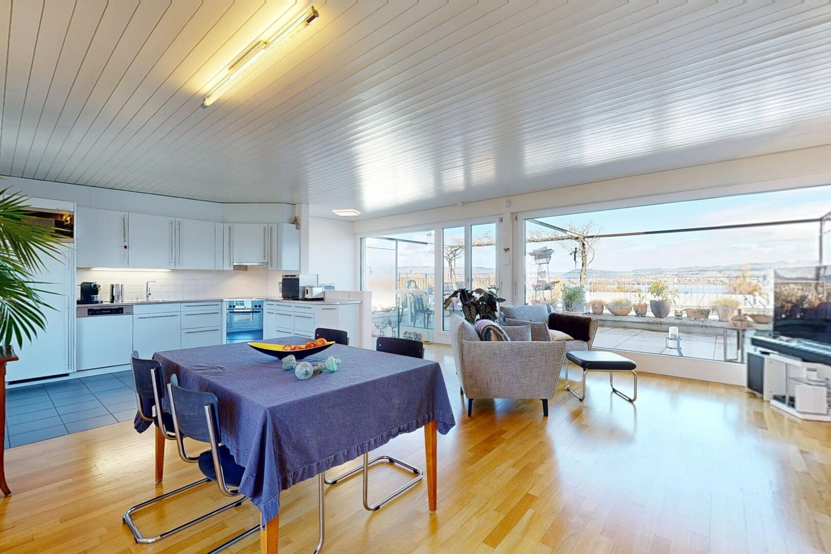 wohn- / esszimmer mit wood finish floor, holzfußboden, inside property, fernseher, und natural light