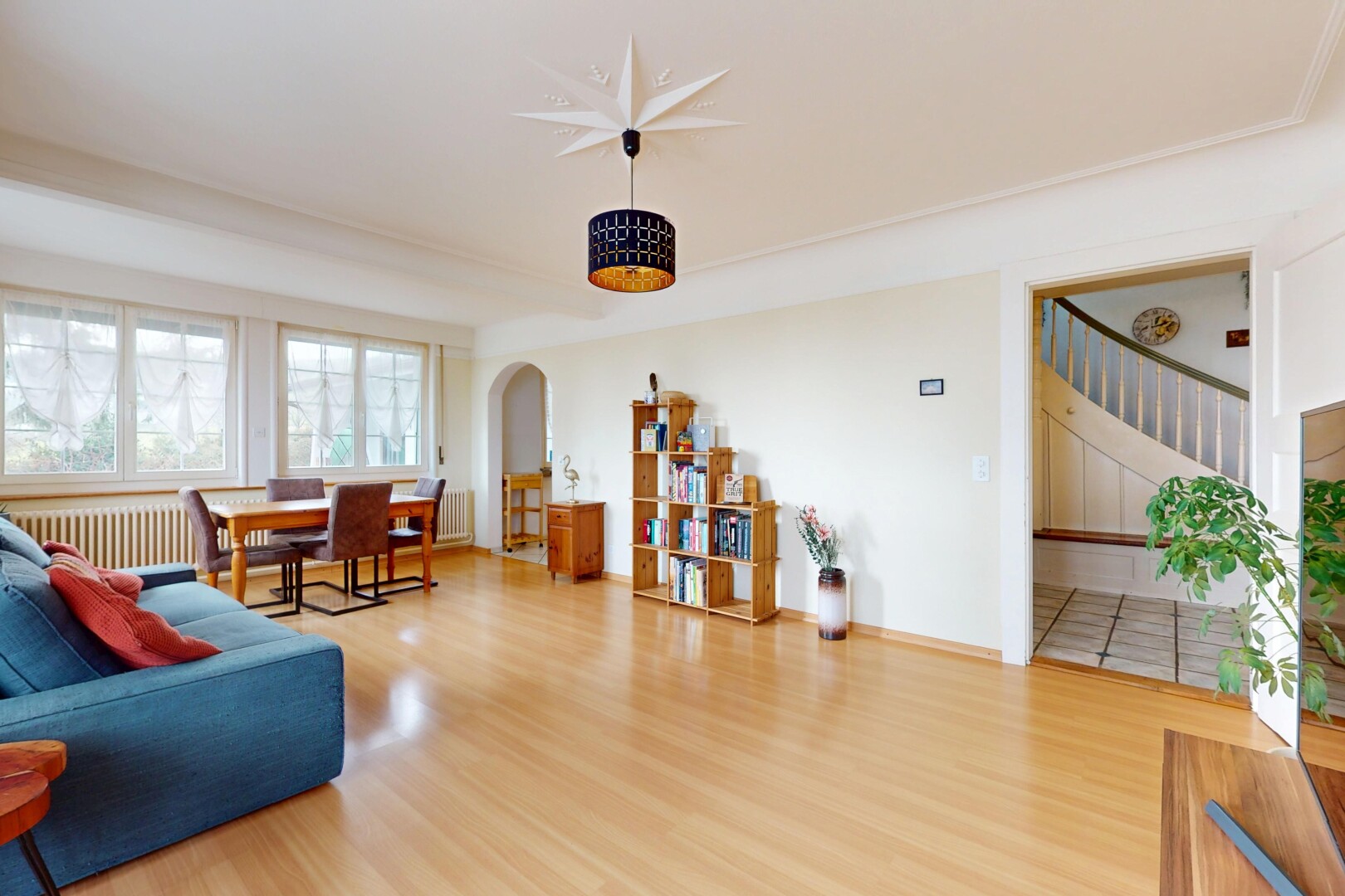 salon / salle à manger avec radiateur, lumière naturelle, passerelles voûtées, et plancher de bois