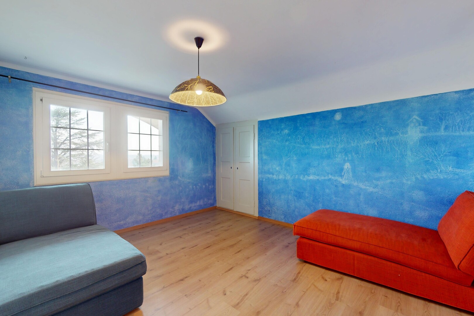 salon avec lumière naturelle, plafond voûté, plancher de bois, et plafond bas