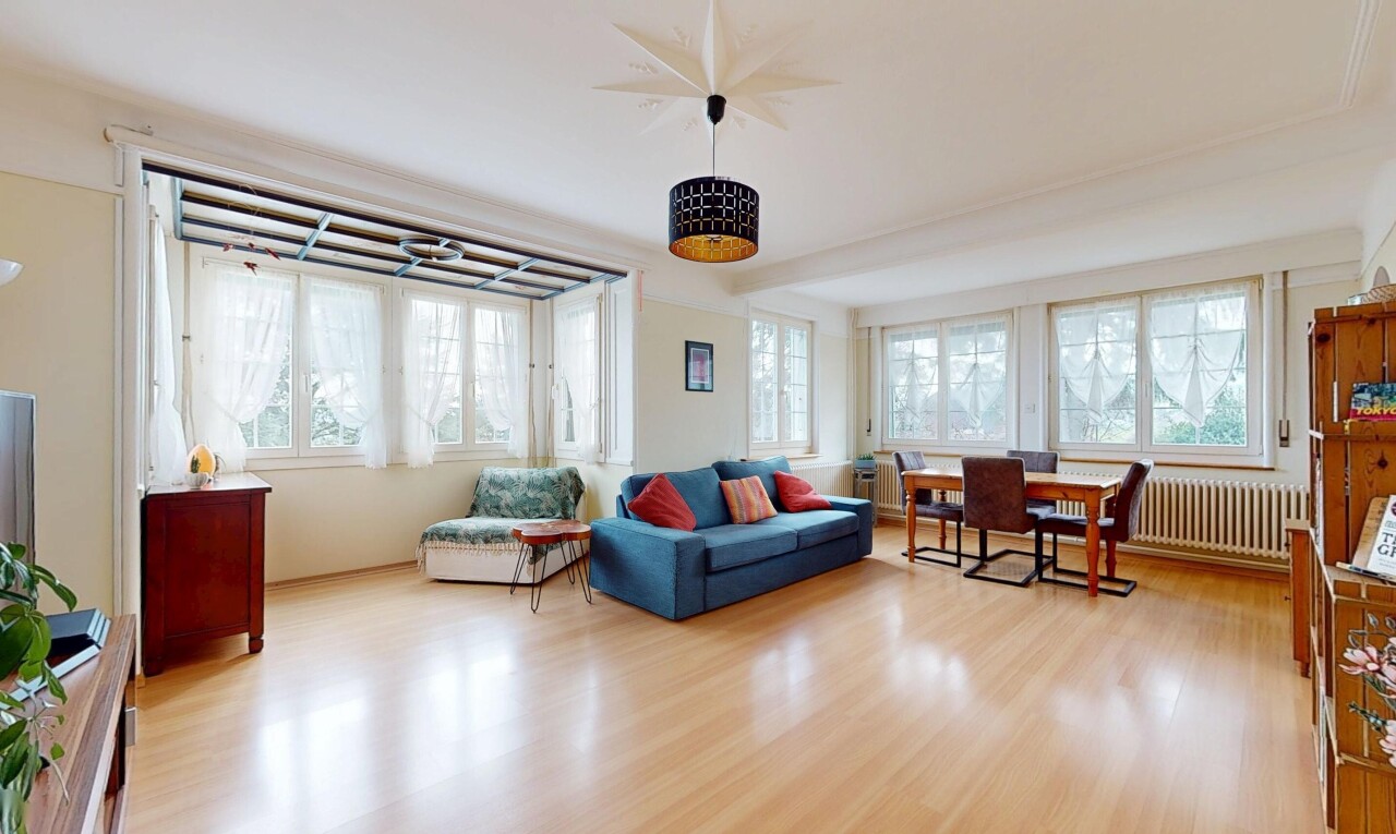salon / salle à manger avec radiateur, plancher de bois, et lumière naturelle