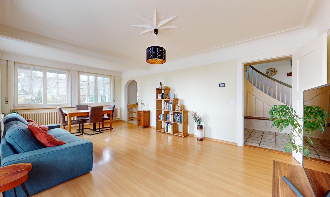 salon / salle à manger avec radiateur, lumière naturelle, passerelles voûtées, et plancher de bois