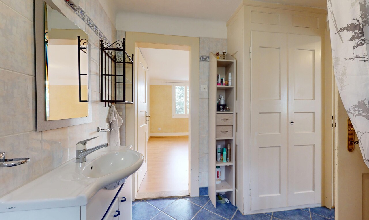 salle de bains avec crédence, vasque, meuble-lavabo, miroir, et carrelage