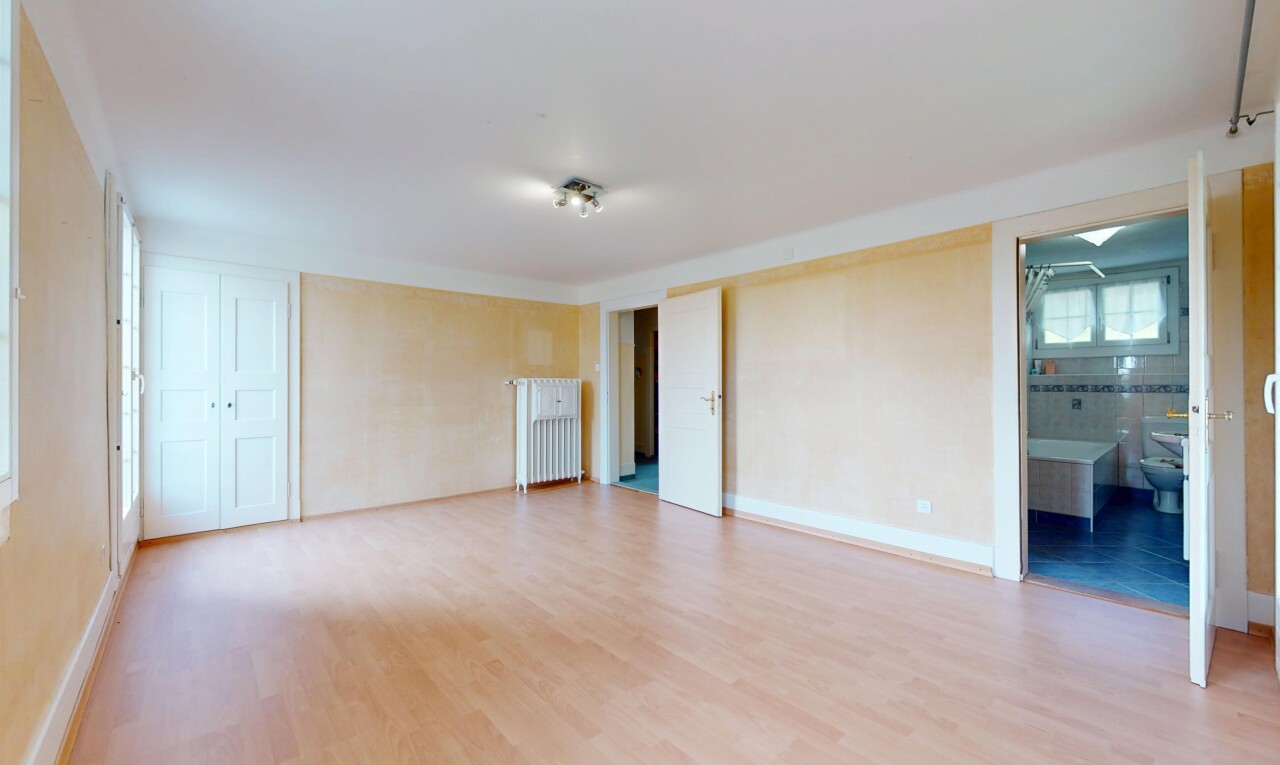 pièce vide avec radiateur, plancher de bois, et lumière naturelle