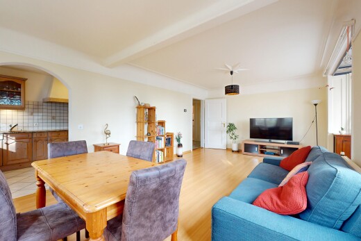 salon / salle à manger avec télévision, plancher de bois, et poutres apparentes