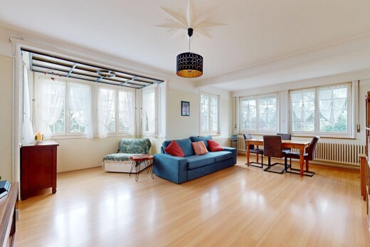 salon / salle à manger avec radiateur, plancher de bois, et lumière naturelle