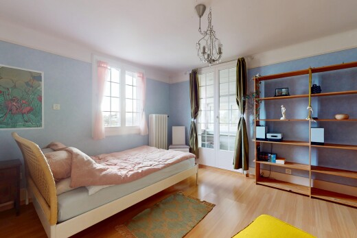 chambre avec radiateur, plancher de bois, lumière naturelle, et lustre