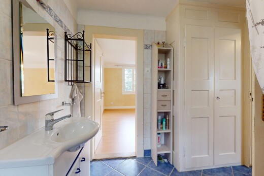 salle de bains avec crédence, vasque, meuble-lavabo, miroir, et carrelage