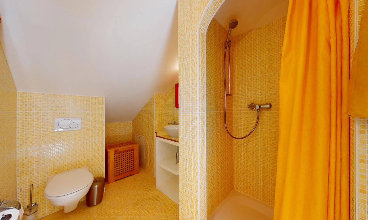 salle de bain avec mur carrelé et toilettes