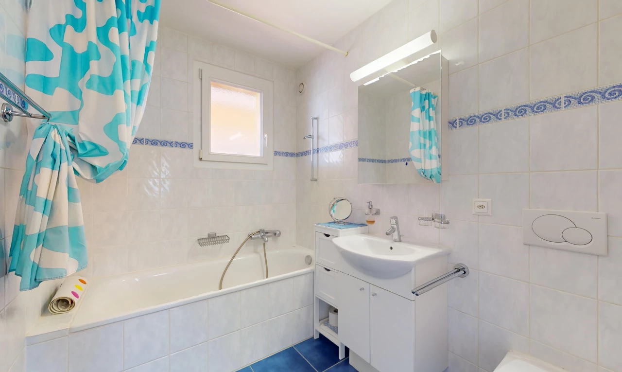 salle de bain avec miroir, mur carrelé, carrelage, lumière naturelle, et meuble-lavabo