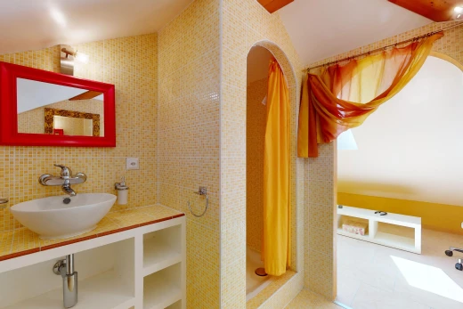 salle de bain avec miroir, mur carrelé, crédence, douche, et vasque
