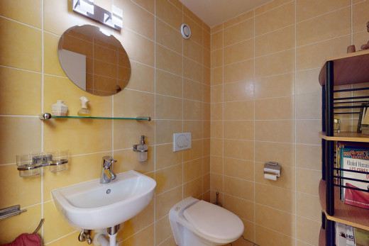 bathroom featuring sink, toilet, and tile walls