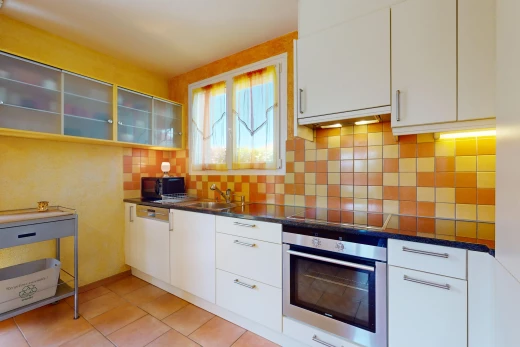cuisine avec cuisinière, lumière naturelle, meubles blancs, et four