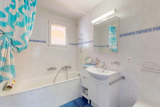 salle de bain avec miroir, mur carrelé, carrelage, lumière naturelle, et meuble-lavabo