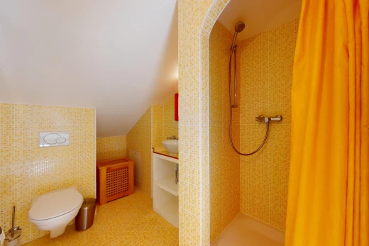 salle de bain avec mur carrelé et toilettes