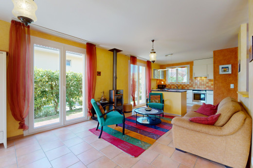 living room with a wealth of natural light, a wood stove, and light tile floors