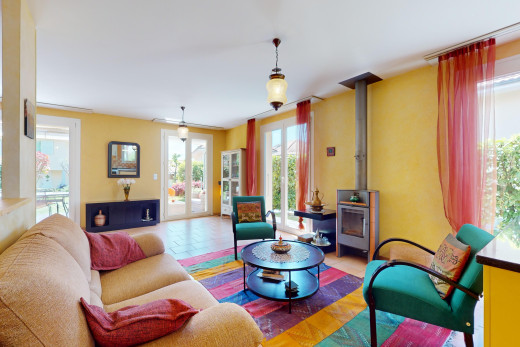living room with a healthy amount of sunlight, tile flooring, and a wood stove