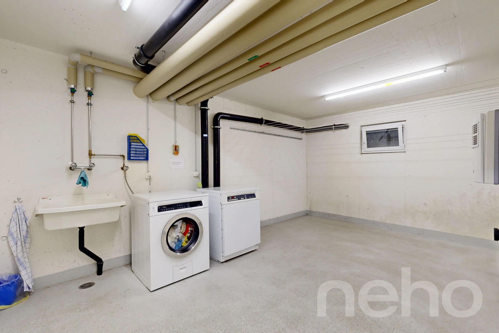 laundry area featuring a sink and concrete flooring