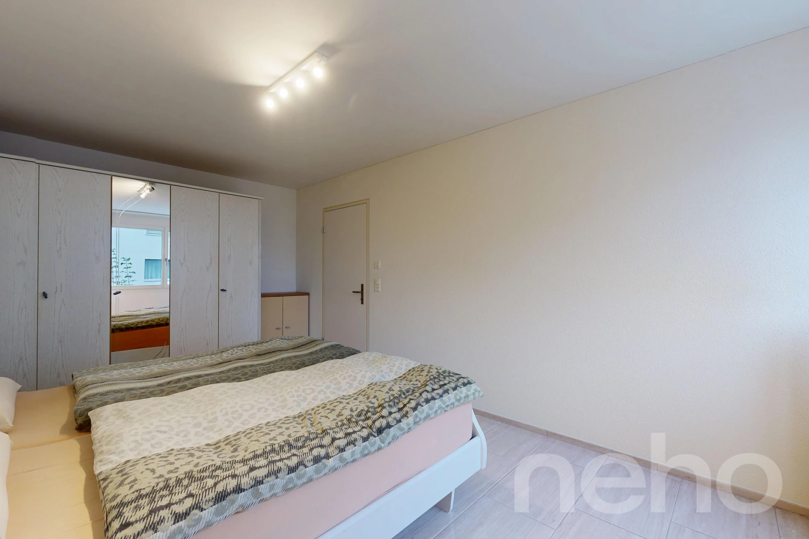 room / bedroom featuring rail lighting and a closet