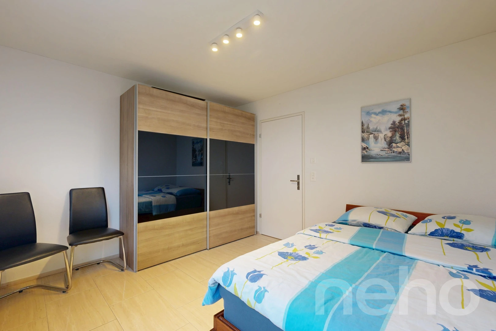 room / bedroom with rail lighting, a closet, and light wood-type flooring