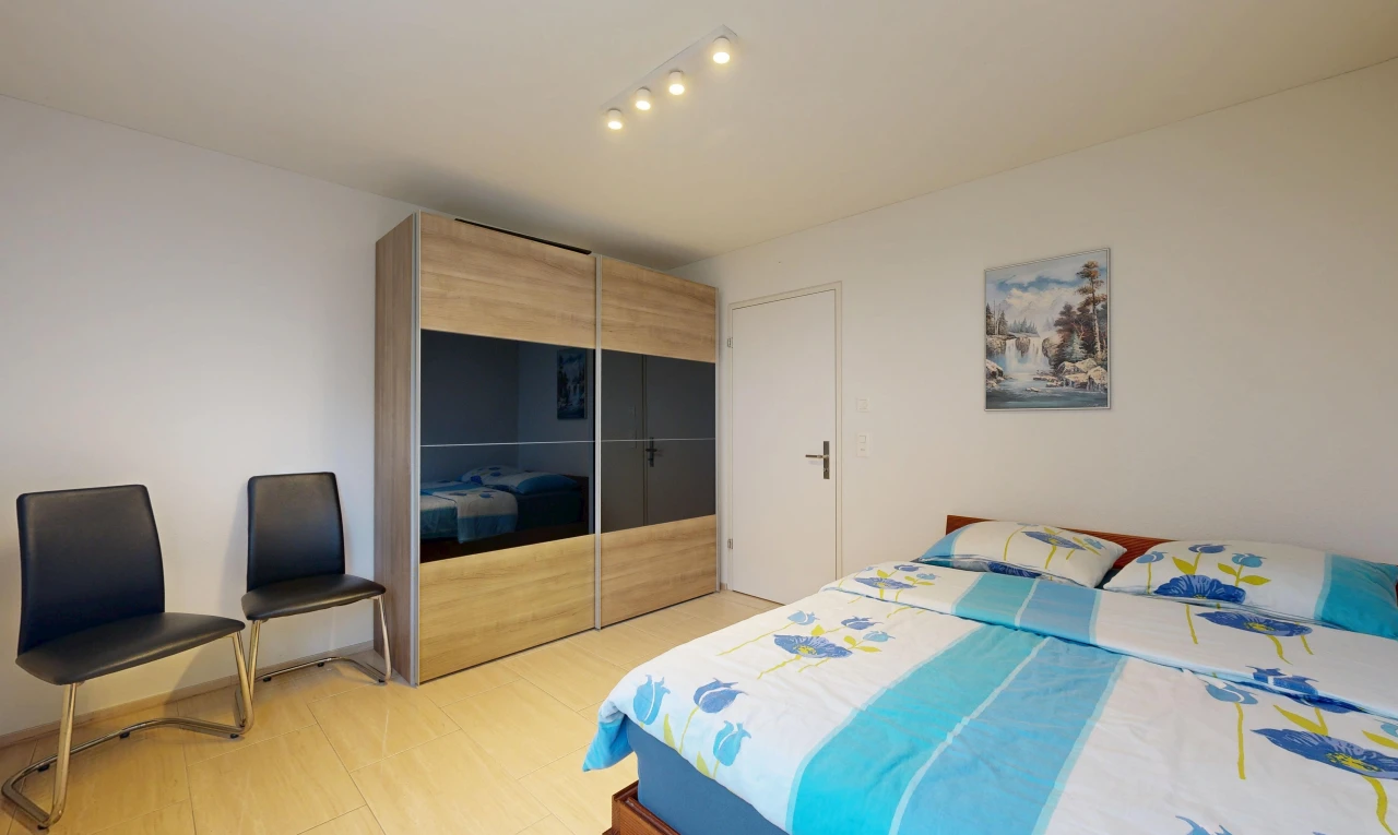 room / bedroom with rail lighting, a closet, and light wood-type flooring