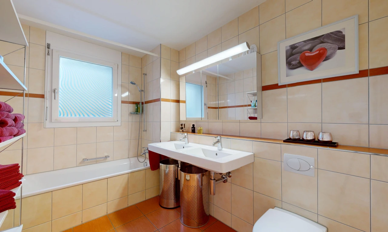 bathroom with tile walls, tiled shower / bath combo, and light tile patterned flooring