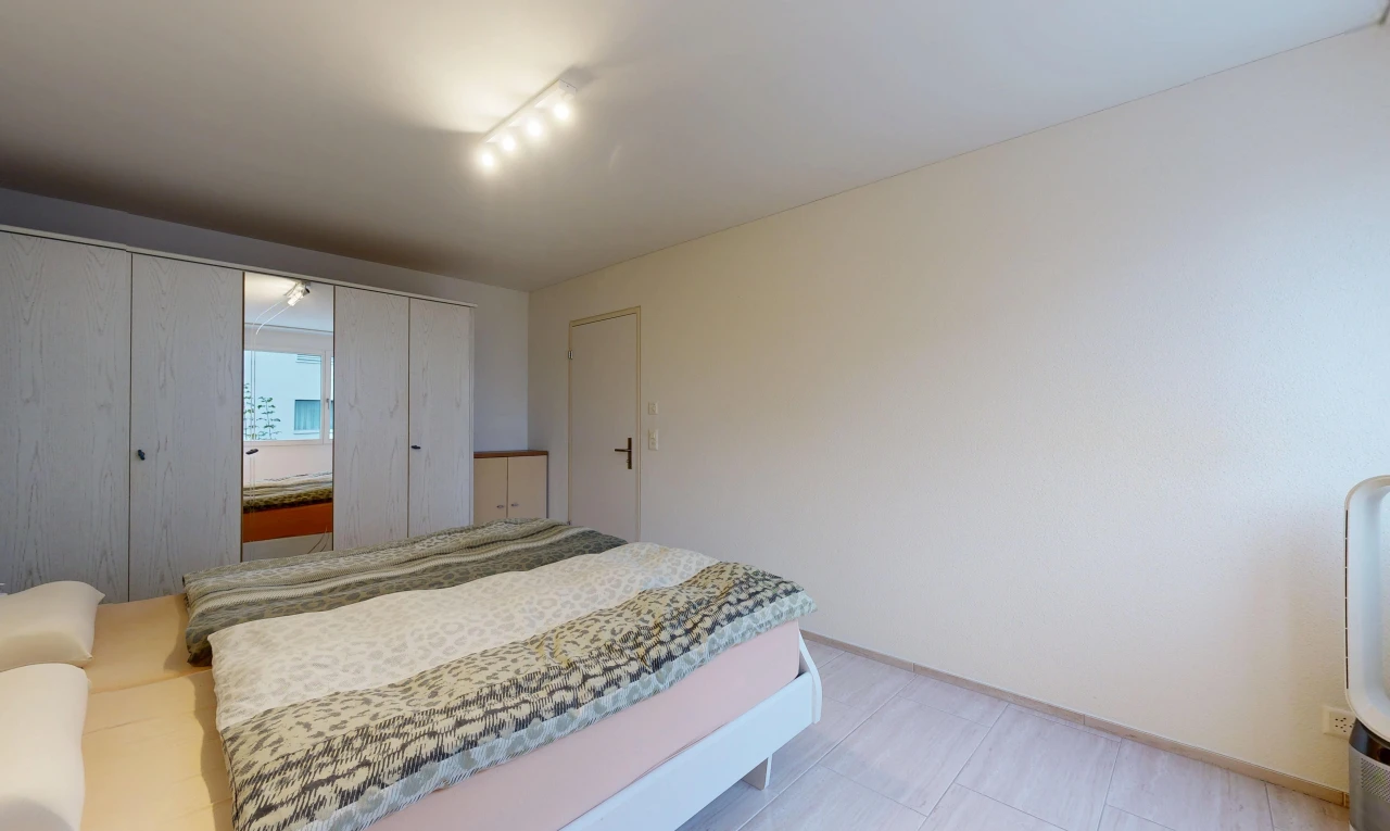 room / bedroom featuring rail lighting and a closet