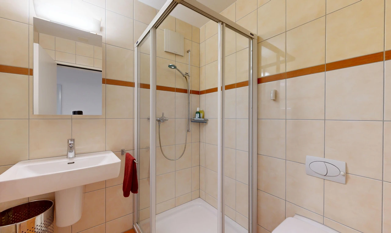 full bath with a shower stall and tile walls